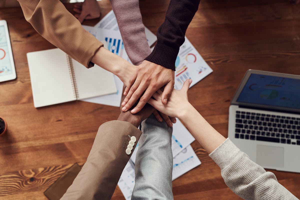 Mani che si uniscono al centro, simbolo di partnership